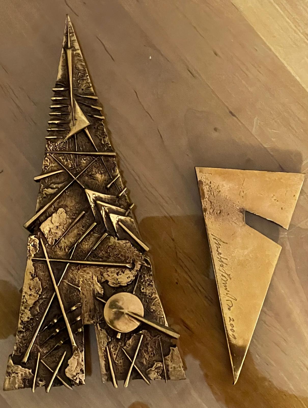 La base triangolare con la firma incisa a mano: «Arnaldo Pomodoro 2009».